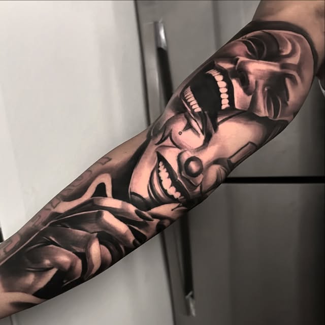 Black and grey realism tattoo featuring two expressive clown portraits on a forearm